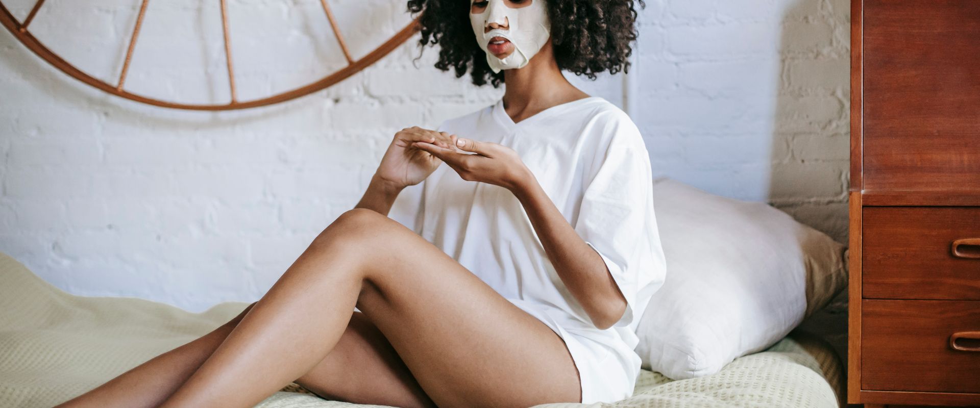 Kvinna med sheet mask i sängen